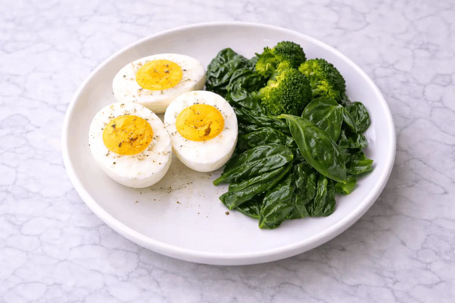 Régime aux œufs : repas restrictif simple avec des œufs durs et quelques légumes sur une assiette blanche