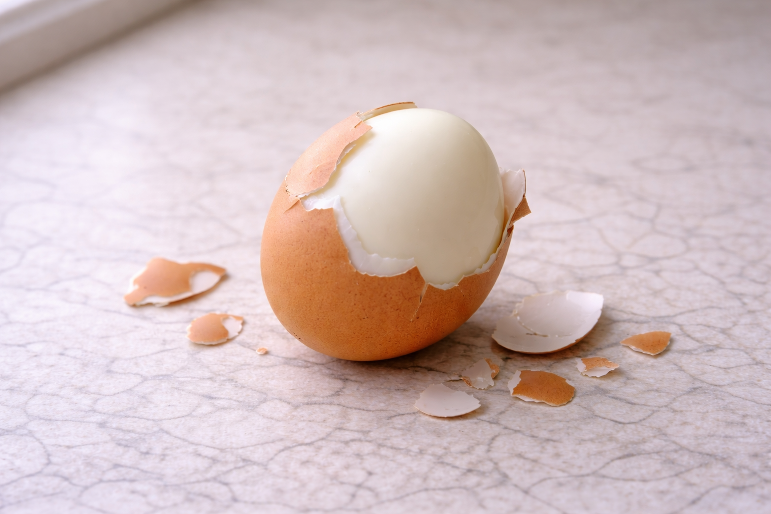Partially peeled hard-boiled egg with shell coming off cleanly