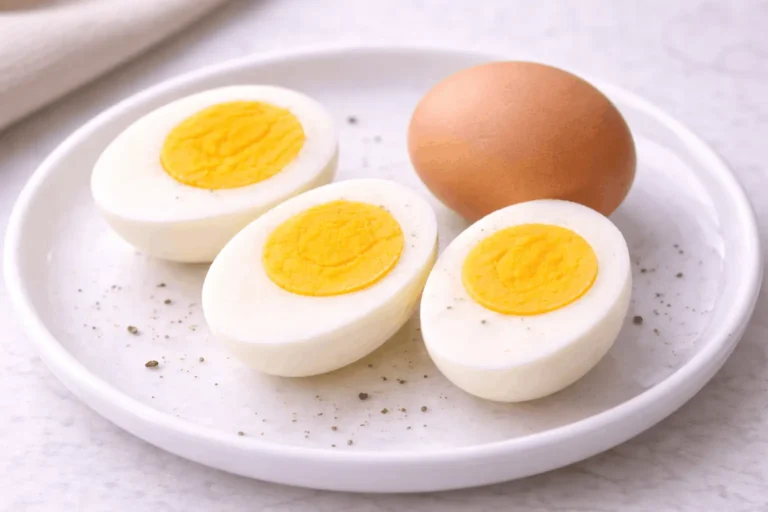 Perfect hard-boiled eggs cut in half showing bright yellow firm yolk with no green ring and fully set whites